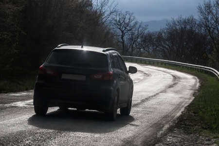 car moves along a winding mountain road after rain.