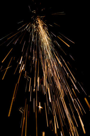 bright sparks of metal against dark backgroundの写真素材