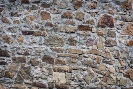 Background.Stone wall of rough unprocessed stones.の写真素材