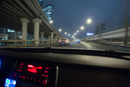 view from the driving car on night traffic in the city centerの写真素材