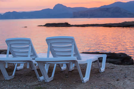 Sun loungers by the sea at sunset
