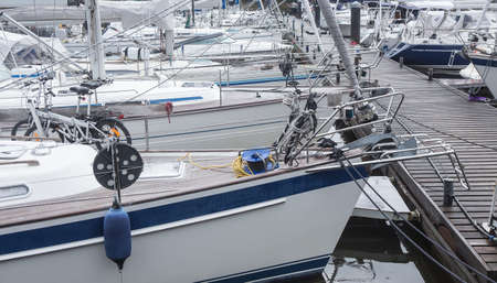 White sailing yachts moored at the pier.