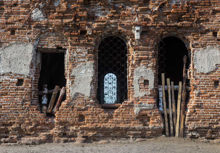 facade and arched windows of an old abandoned brick buildingの写真素材
