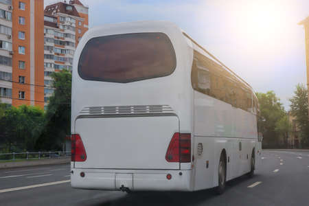 Tourist bus moves along a city streetの写真素材