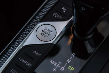 Engine power button and gearshift lever on the car panel