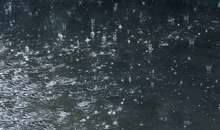 rain drops falling in pool on asphaltの写真素材