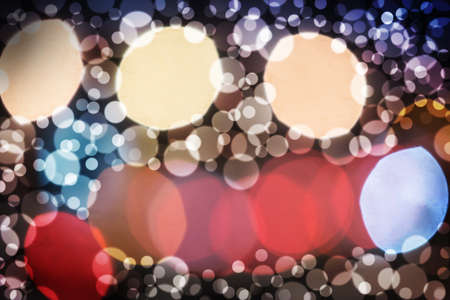 Abstract blur bokeh on a dark background. Round colored spots of light on a dark background.