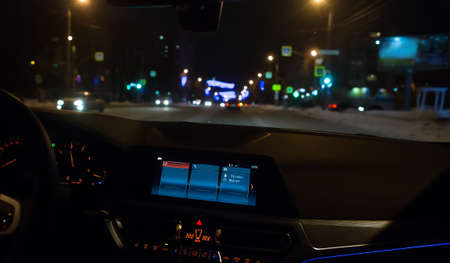 car moves on a street in a city on a winter night. Car inside view