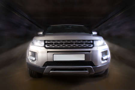 SUV moves on the road at night. Front view