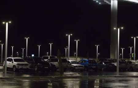 Night car parking lit by street lamps