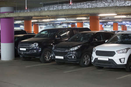 Cars in an underground parking lot under a supermarket