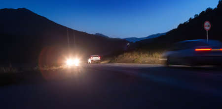 Cars move on a night road in the mountains. Motion blur.の写真素材