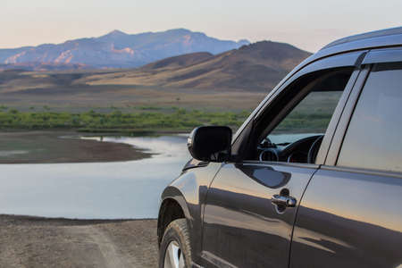 Car in nature against the backdrop of a mountain landscape at sunset.の写真素材