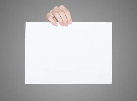 White blank sheet held from above by female fingersの写真素材