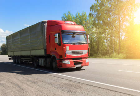 Big truck semi-trailer moves on a suburban highway