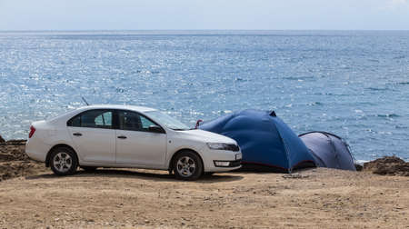 Car and tourist tents by the sea in summerの写真素材