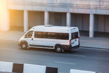 Minibus travels on a city lane in the afternoonの写真素材