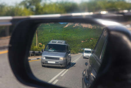 View of the road and cars through the rearview mirror