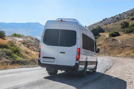 Minibus Moves along the Mountain Winding Road to the Sea in summer