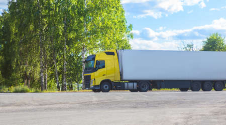 Yellow Truck Drives on a Suburban Highway