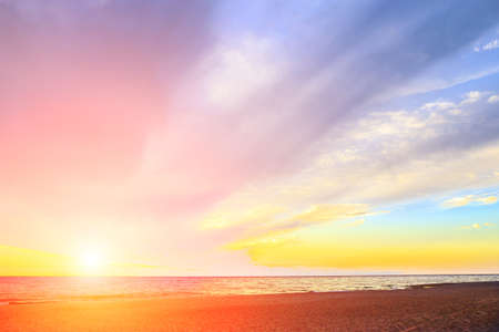 Beautiful Cloudy Sky at Dawn over the Sea at the Sandy Shoreの写真素材
