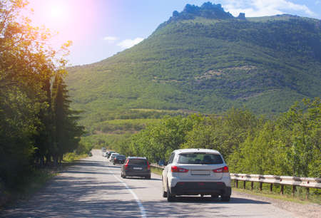 Cars move along a winding mountain road on a summer dayの写真素材