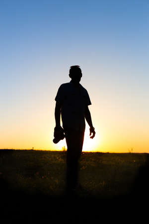 silhouette of a man with a camera against the backdrop of the setting sun.の写真素材