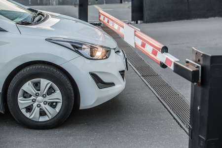 White Car Stands at a Closed Barrier Close-up