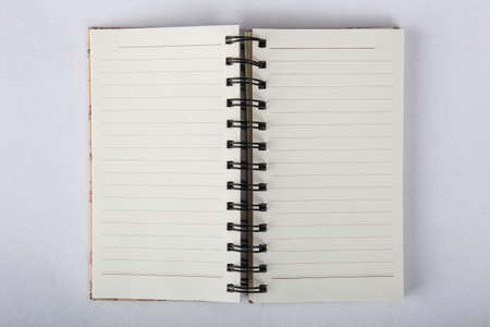 Opened paper notebook on blank pages on white background close-up