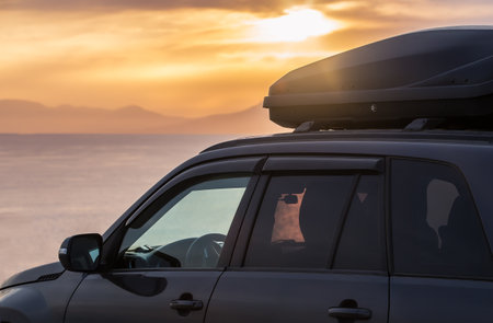 SUV car near the seashore at sunset against the background of mountains