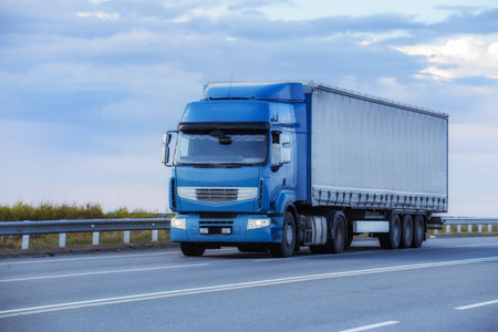 Truck driving on the highway against the background of the cloudy skyの写真素材
