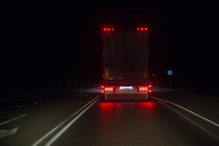 Truck moves at night on country road. Back view.の写真素材