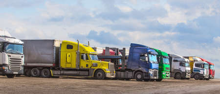 Trucks in the parking lot under the blue cloudy skyの写真素材