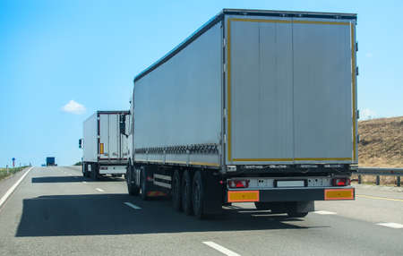 Trucks move along a suburban highway in opposite directions