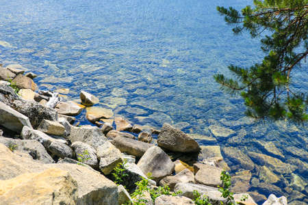 Beautiful rocky lake shore on a summer sunny day.の写真素材