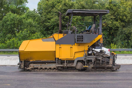 Road equipment. Asphalt paver at the construction of a new roadの写真素材