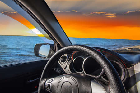 View from the car to the shore of the lake at sunset
