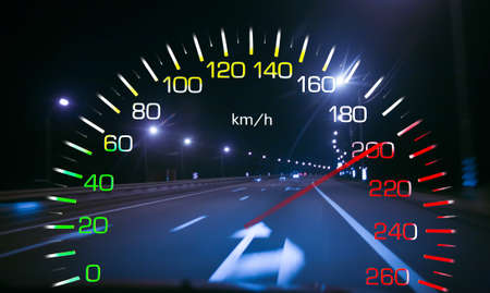 Car speedometer on the background of the night highway. Dangerous overspeeding concept.の写真素材