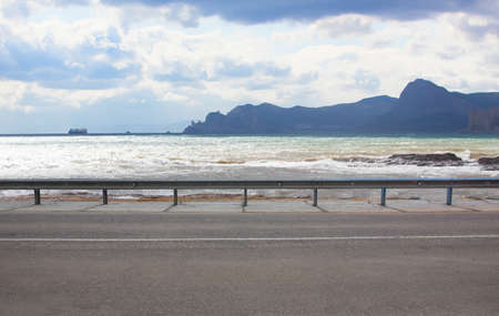 Asphalt empty road along the seashore lit by the sun