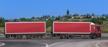 Truck with trailer moves along country road. Side view.の写真素材
