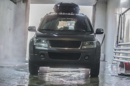 Wet Car in a car wash close-up, front view.