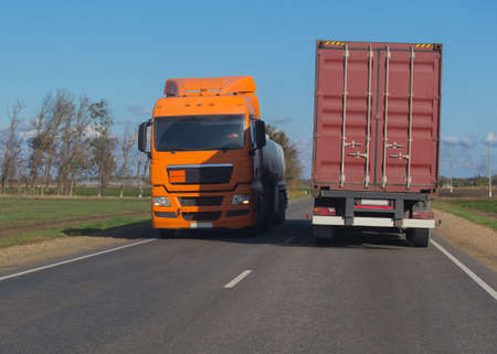 Trucks moving in opposite directions on a country roadの写真素材