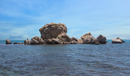 Beautiful rock in the sea against a cloudy skyの写真素材