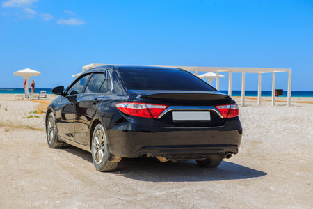 Car on a sandy beach by the sea on a summer day