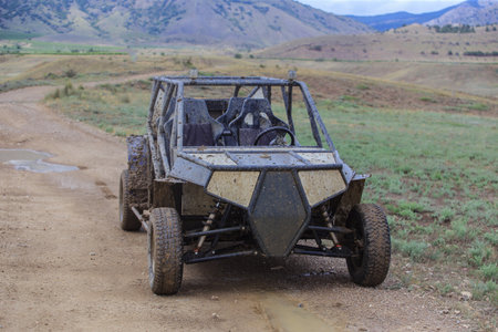 Buggy on rugged mountainous terrain in rainy weatherの写真素材