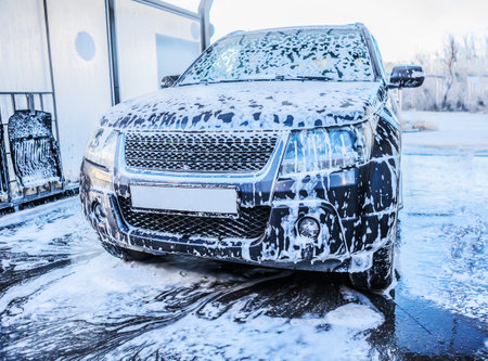 Car in the foam at the car wash close-upの写真素材