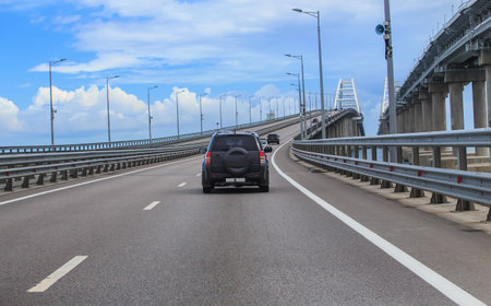 Cars moving towards the arches of the Crimean bridge on a summer dayの写真素材