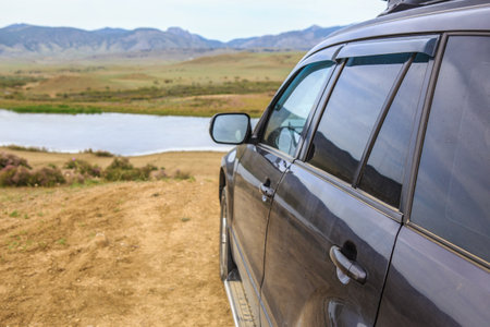 SUV on the background of a mountain landscape with a riverの写真素材