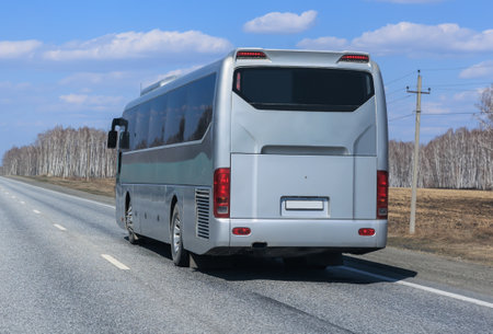 Tourist bus moves on a country highway close-upの写真素材