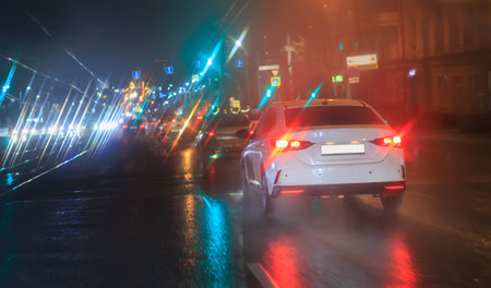 Car traffic at night in the rain on a city streetの写真素材